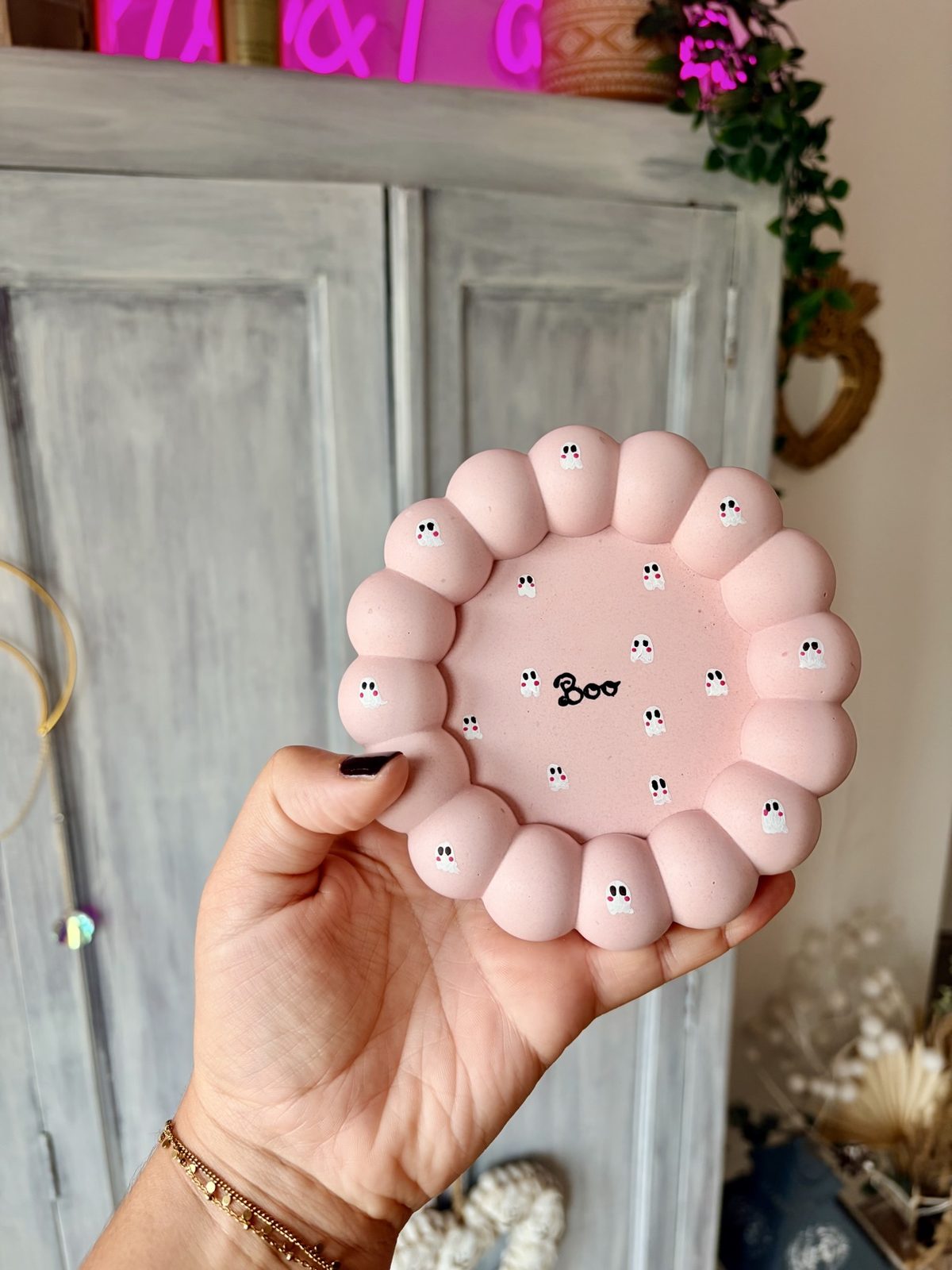 Vide-poche Boo en jesmonite rose aux petits fantômes, tenu à la main